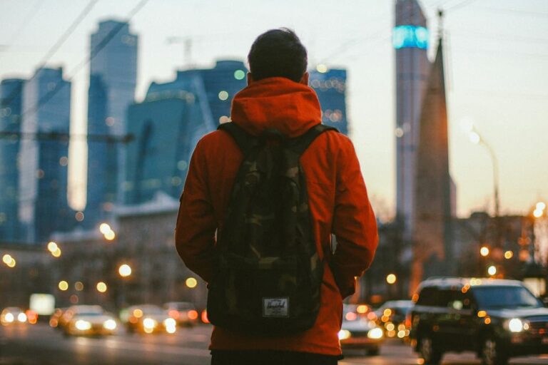 a-man-with-a-backpack-is-standing-on-the-street
