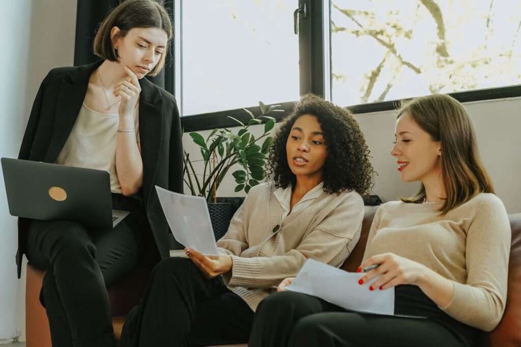 women-sitting-on-a-sofa-while-talking-business