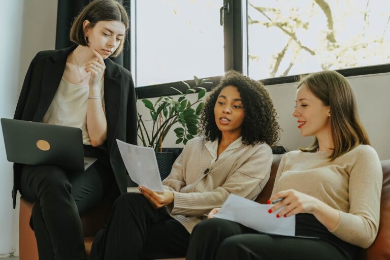 women-sitting-on-a-sofa-while-talking-business