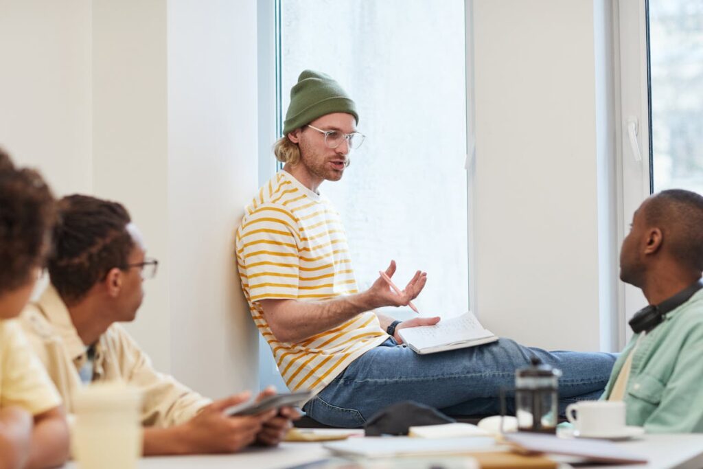 man-in-yellow-and-white-striped-shirt-sitting-beside-the-glass-window