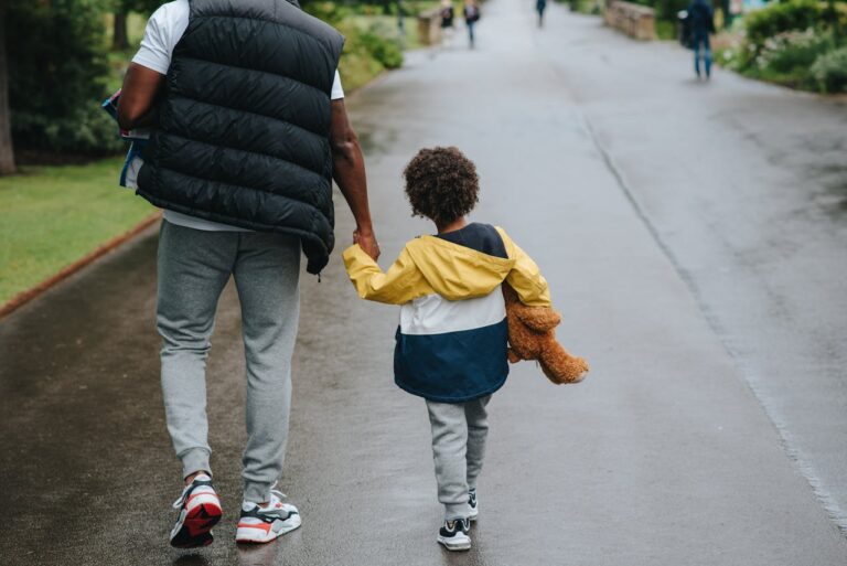 man-with-son-holding-hands-strolling-on-roadway