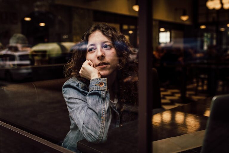 woman-wearing-blue-denim-jacket-putting-her-right-arm-on-her-cheek