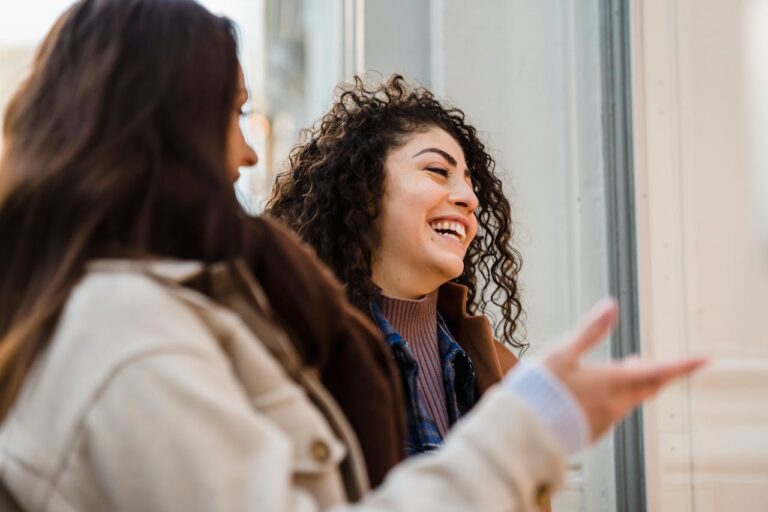 cheerful-young-diverse-ladies-laughing-on-street