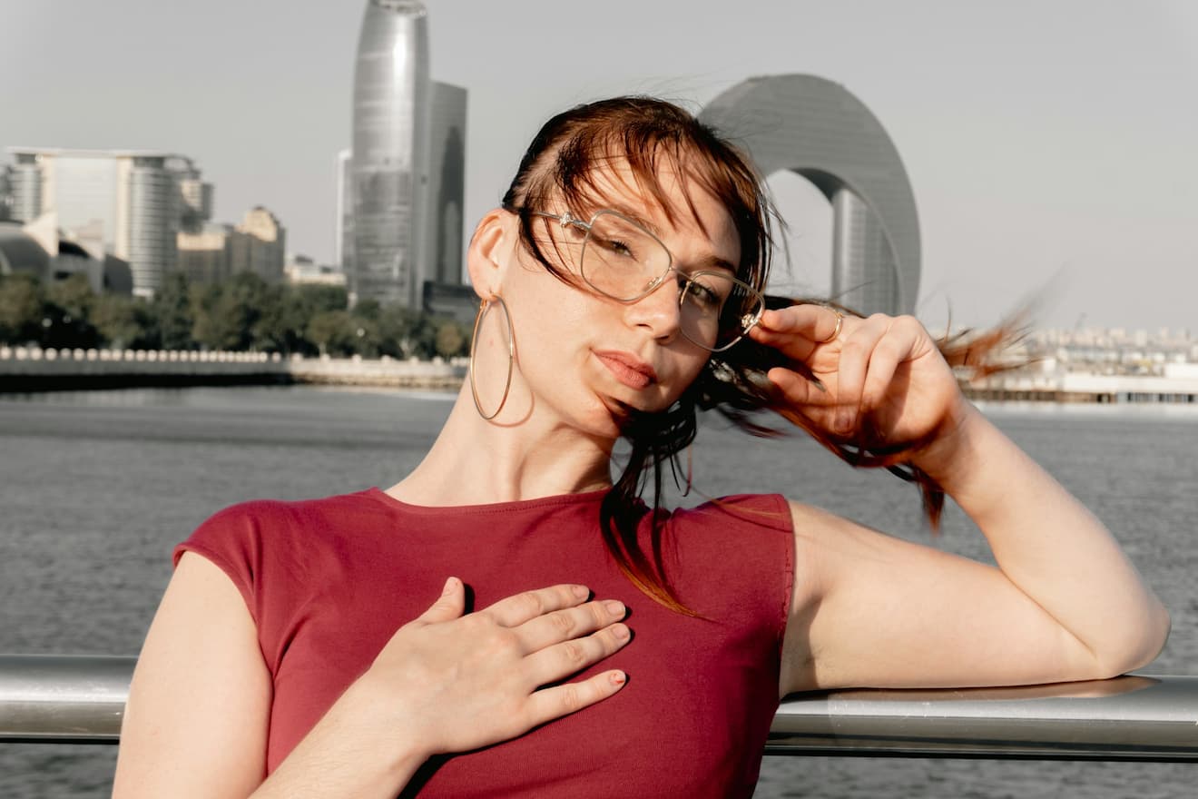 woman-with-glasses-adjusts-hair-with-city-skyline