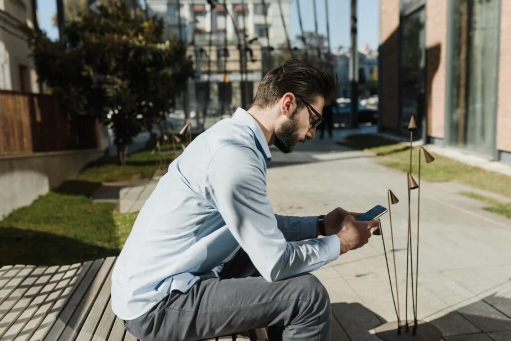 a-man-sitting-on-the-bench-using-smartphone