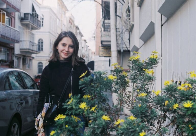 woman-in-black-jacket-standing-beside-a-plant