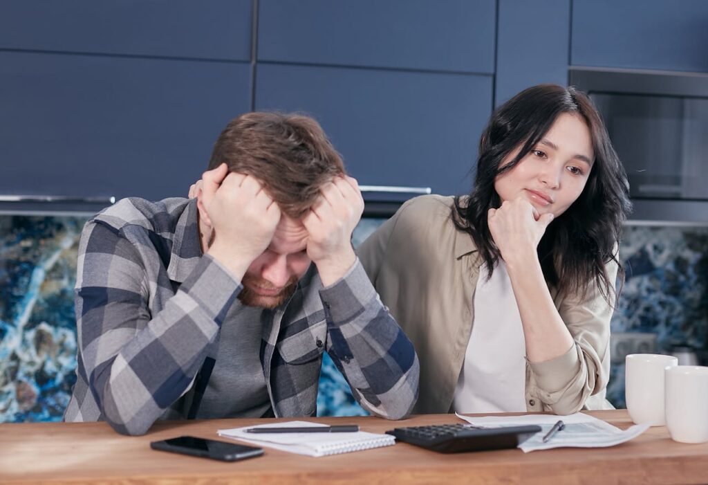 stressed-man-sitting-at-a-table-beside-a-woman