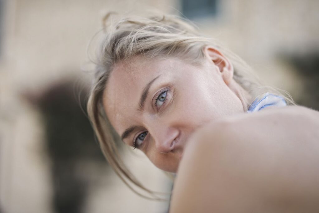 woman-with-mouth-covered-by-shoulder