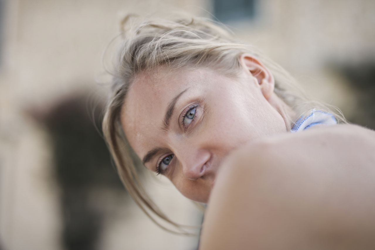woman-with-mouth-covered-by-shoulder