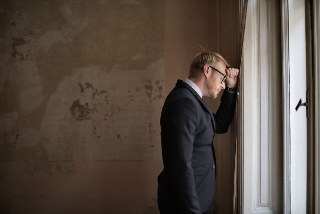 desperate-evicted-male-entrepreneur-standing-near-window