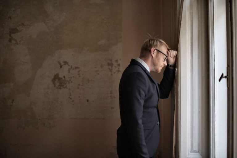 desperate-evicted-male-entrepreneur-standing-near-window