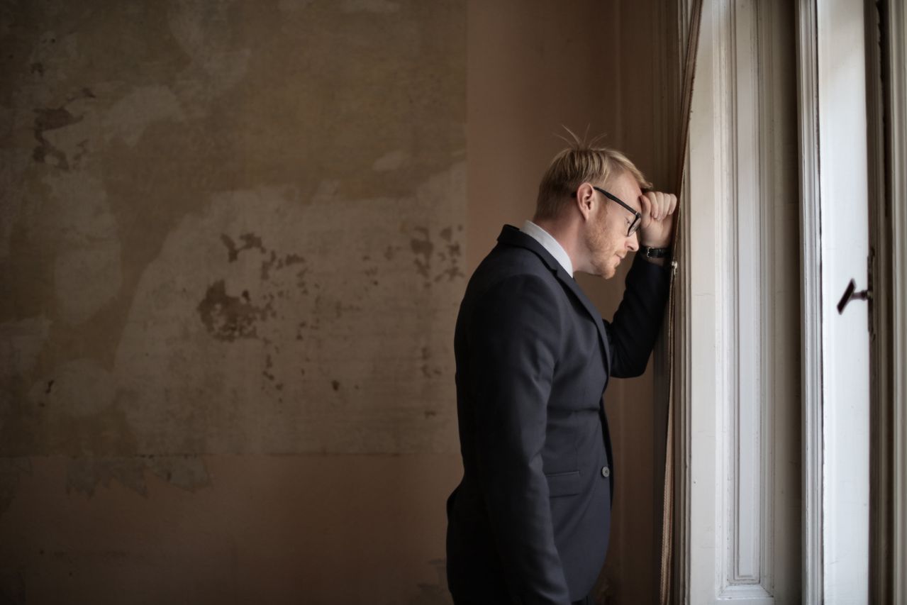desperate-evicted-male-entrepreneur-standing-near-window